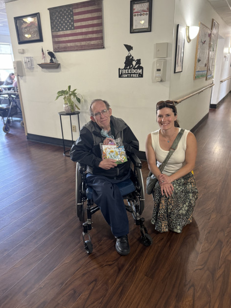 A senior resident and visitor sharing a May Day basket during SANEWA's community outreach project