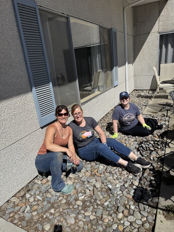 Three SANEWA volunteers working together in a rock garden